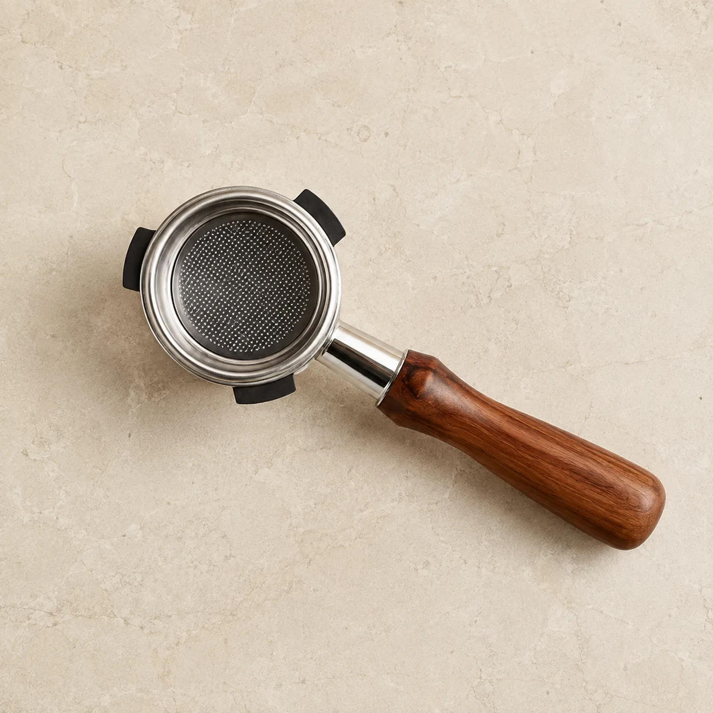 Puckwell bottomless portafilter with rosewood handle, seen from above on a stone counter